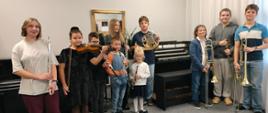 Zdjęcie grupowe uczniów z nowymi instrumentami na tle organów.