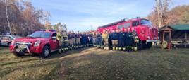 ZDJĘCIE GRUPOWE NA ZAKOŃCZENIE SZKOLENIA NA TLE SAMOCHODÓW POŻARNICZYCH