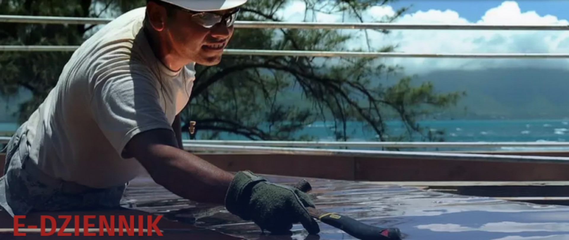 Osoba w białym stroju i kapeluszu pracująca na zewnątrz z widokiem na morze; w rogu napis „E-DZIENNIK”.
