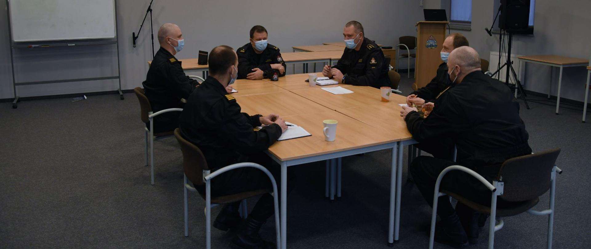 Na zdjęciu zastępca komendanta wraz z Naczelnikiem i dyżurnymi operacyjnymi podczas narady siedzą przy stole 