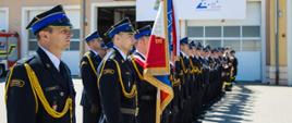 Zdjęcie pododdziału pożarniczego, na czele z dowódcą pododdziału, pocztem sztandarowym, funkcjonariuszami oraz druhnami i druhami OSP z powiatu szczycieńskiego 