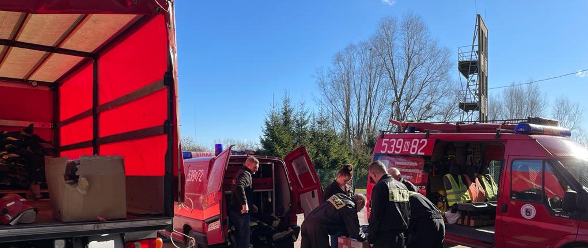 Strażacy segregują i pakują sprzęt pożarniczy, który będzie przekazany strażakom na Ukrainie.