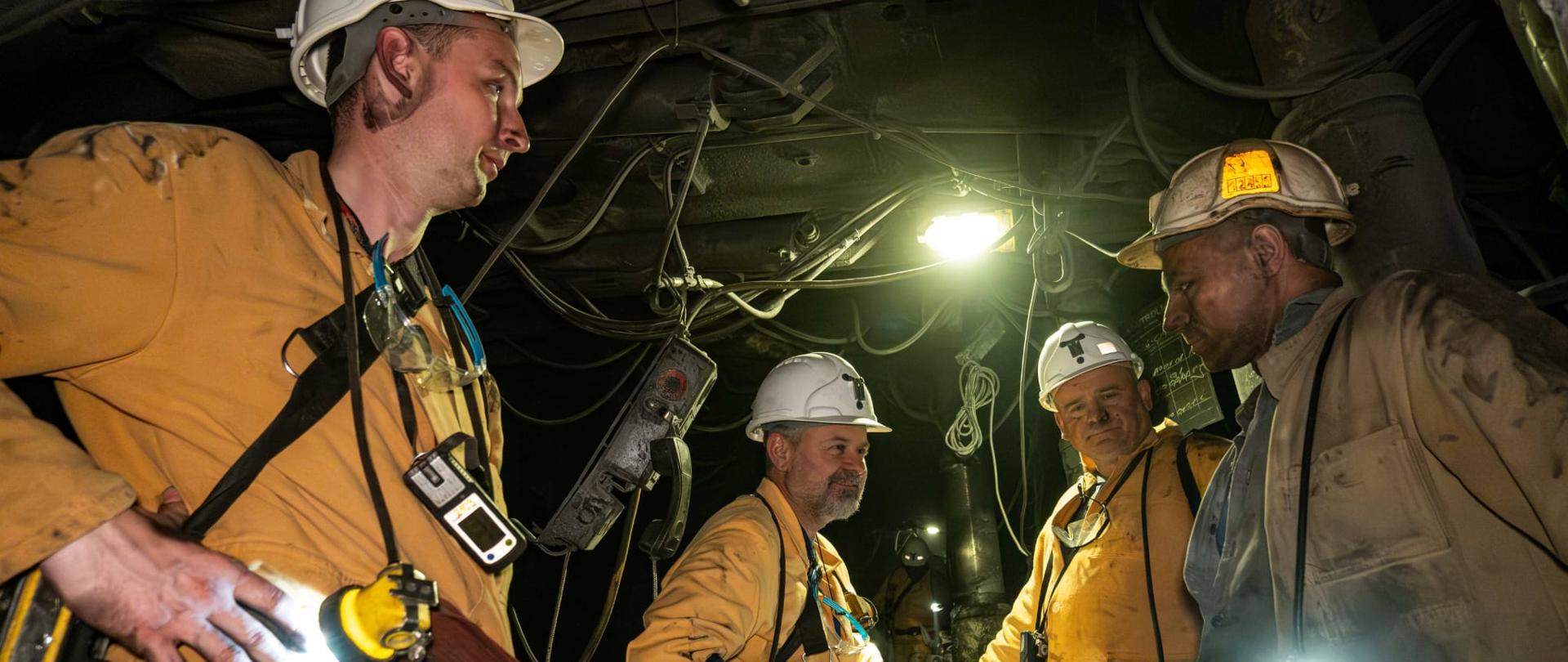 Fot. JSW/ Michał Kaczorek
Wiceminister Grzegorz Wrona z wizytą w kopalni JSW. Ujęcie w kombinezonach górniczych. 