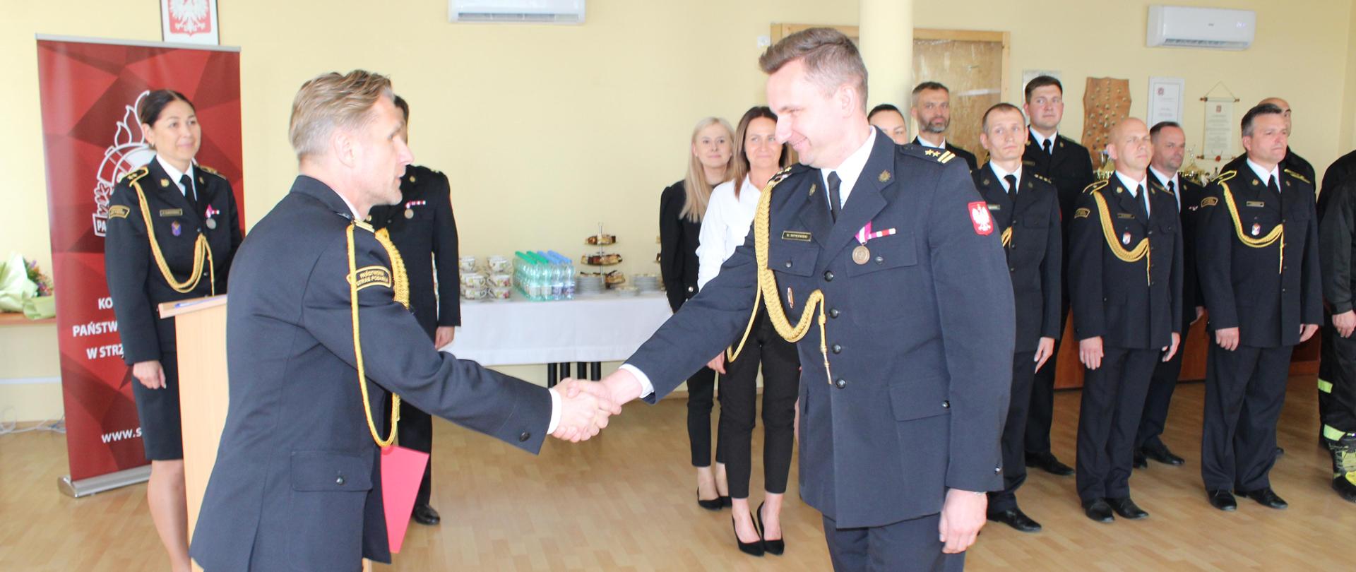 Fotografia przedstawia moment składania gratulacji powołanemu komendantowi przez przełożonego