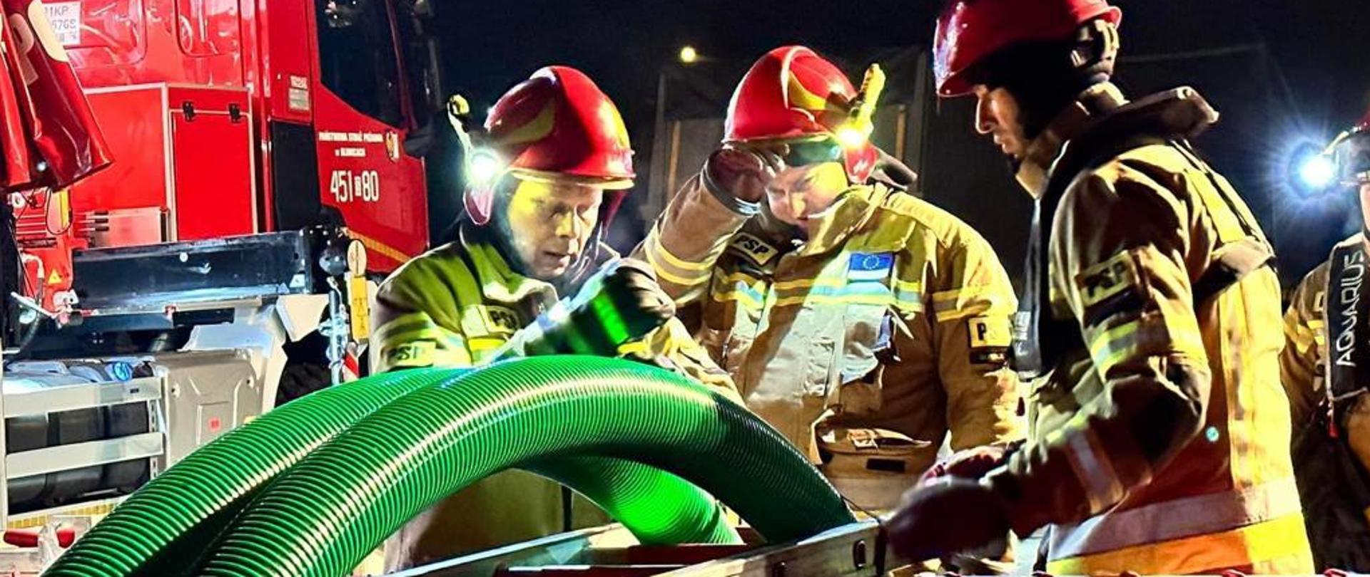strażacy pracujący przy pompie 