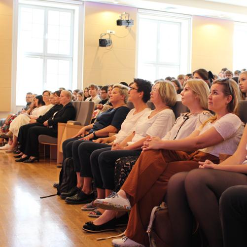 zdjęcie przedstawia publiczność zgromadzoną na miejscach siedzących widowni sali koncertowej