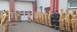 Trwa zmiana służby, dwaj strażacy odchodzący na zaopatrzenie emerytalne wystąpili z szeregu. Komendant Miejski PSP przemawia i dziękuje strażakom za pełnioną służbę.