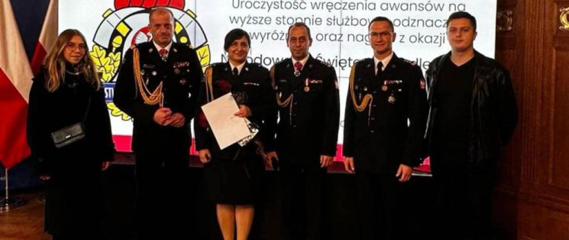 Zdjęcie wykonane na Sali Rycerskiej w Urzędzie Wojewódzkim w Szczecinie. W szeregu stoją strażacy w mundurach galowych. Wśród strażaków awansowana Anna Pedner.