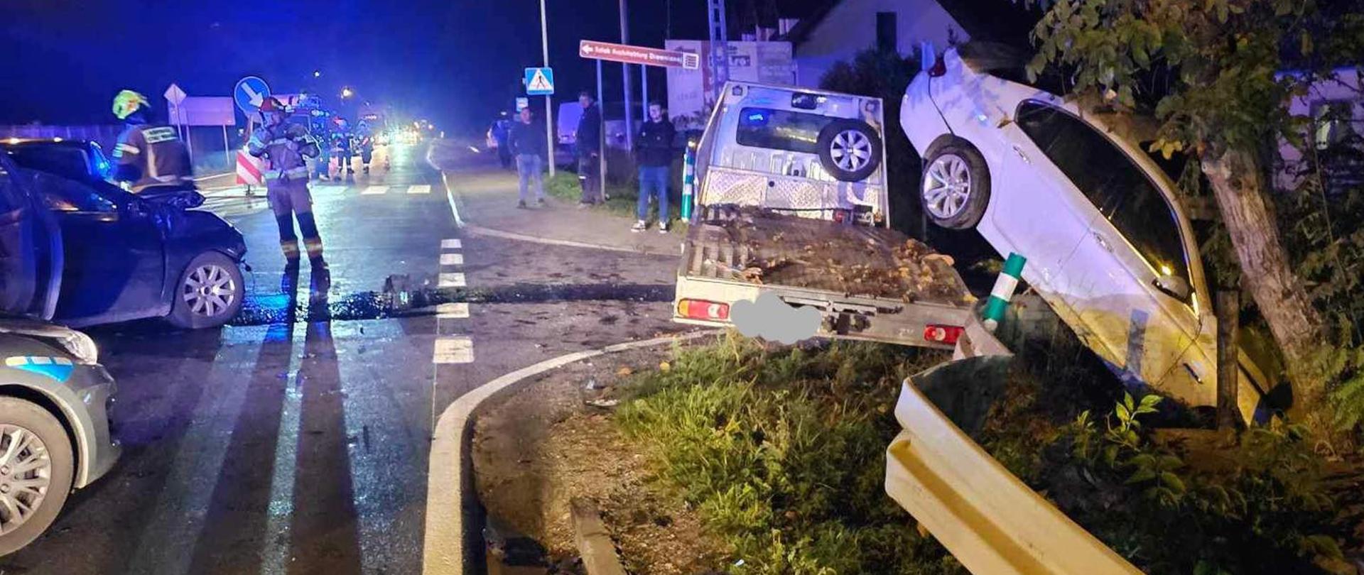 Na zdjęciu widoczne uszkodzone pojazdu na jezdni oraz Dowódcę akcji ratowniczej 