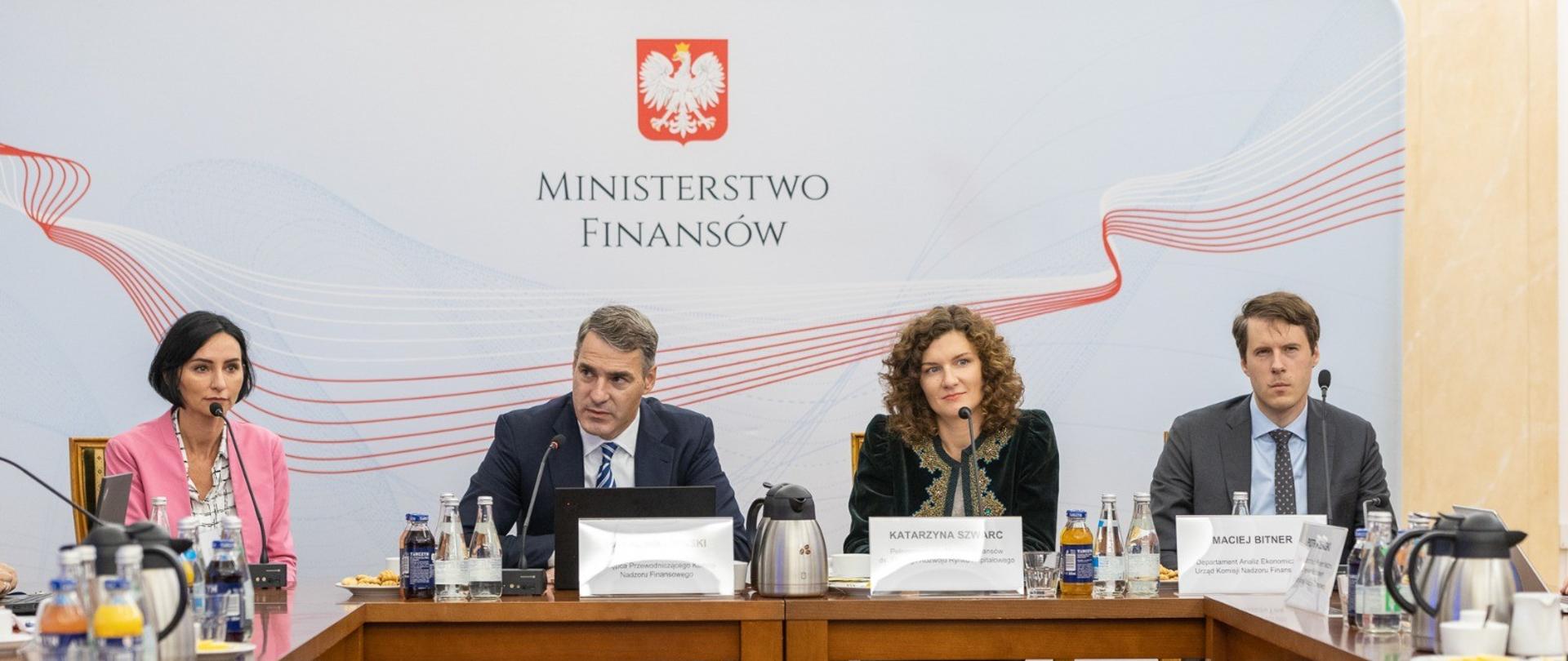 Uczestnicy spotkania, w tle ścianka z napisem Ministerstwo Finansów.