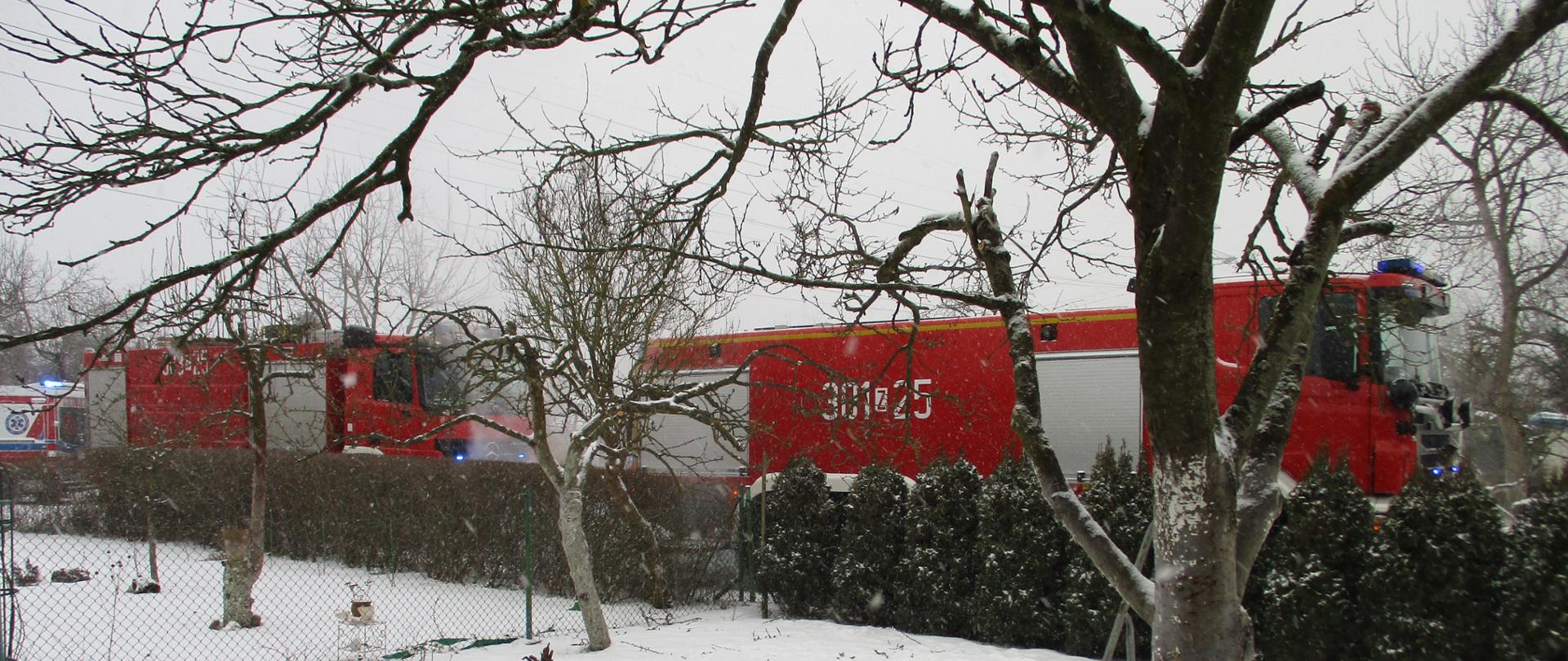 Pojazdy ratowniczo-gaśnicze Państwowej Straży Pożarnej podczas działań gaszenia altany przy ulicy Białowieskiej