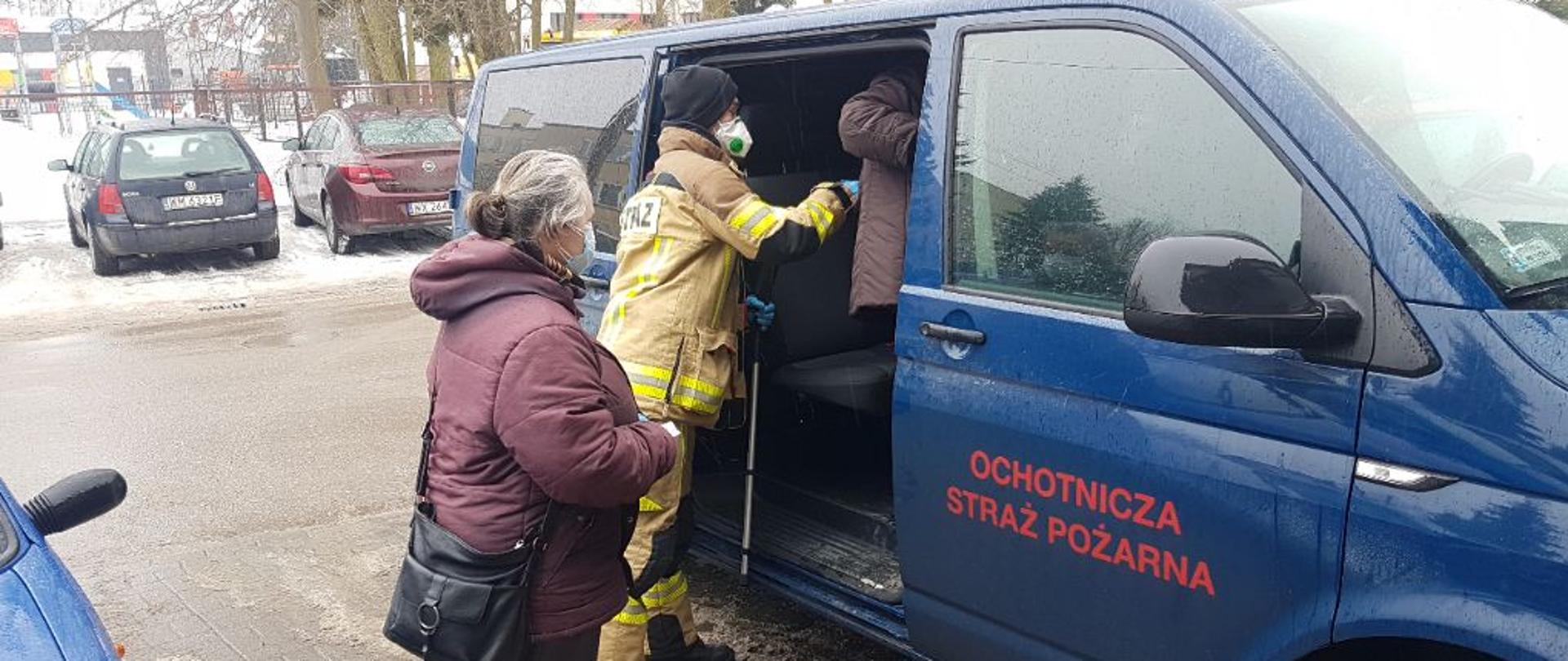 Starsza mężczyzna wsiadający do samochodu OSP Dębe Wielkie.