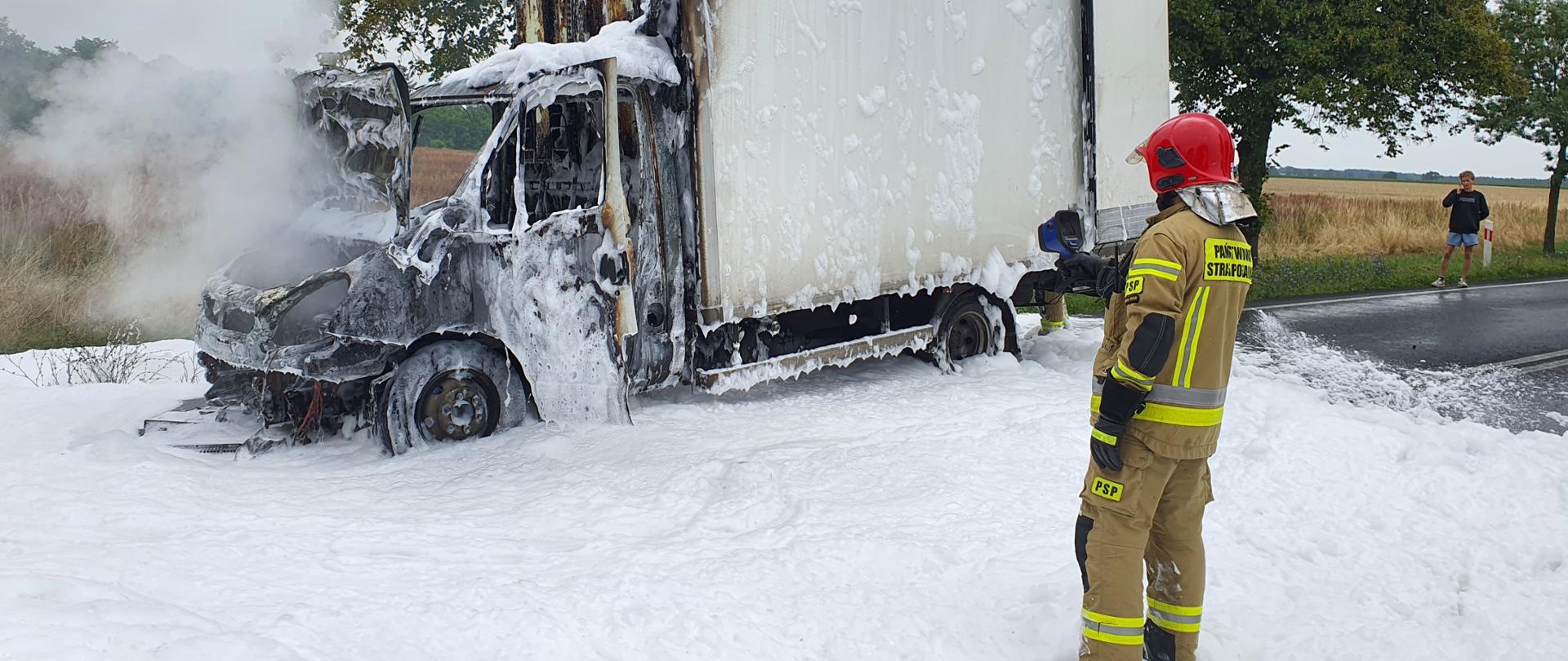 Na zdjęciu strażak z kamerą termowizyjną sprawdza samochód podczas pożaru