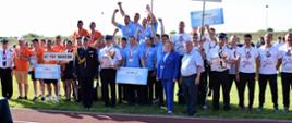 Zawodnicy wyróżnieni medalami oraz osoby wręczające medale i nagrody pozują do fotografii 