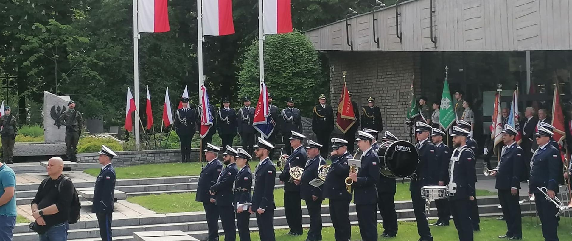 Orkiestra wojskowa wraz z uczestnikami wydarzenia stojąca przy pomniku i Panoramie Racławickiej.
