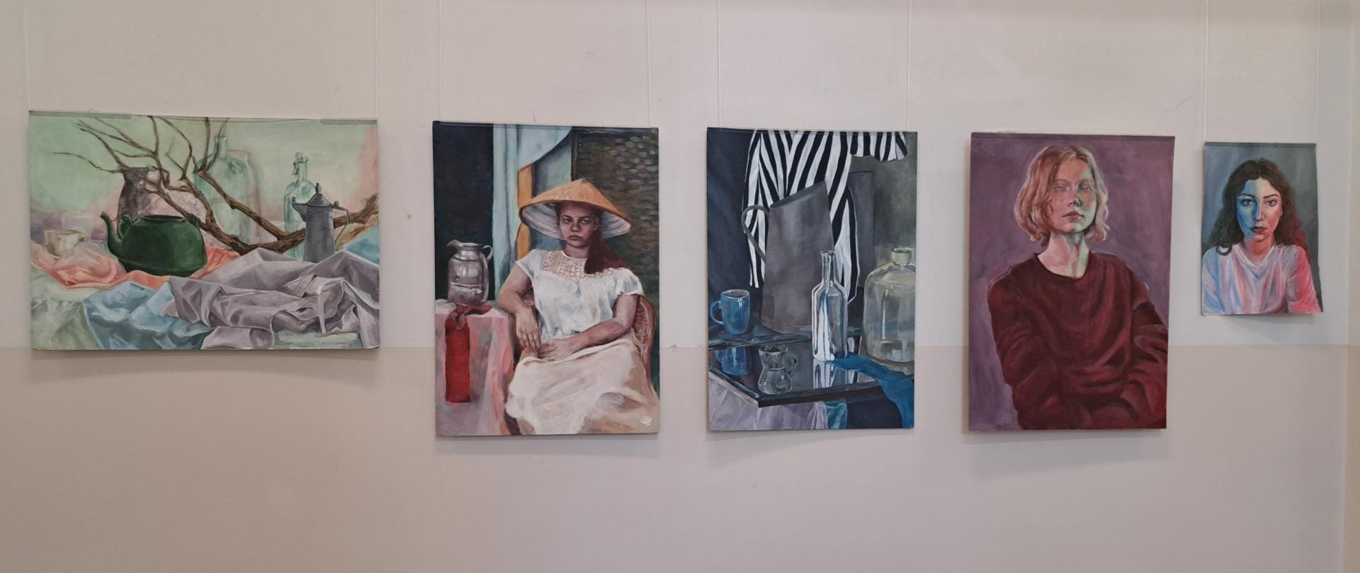 Prace malarskie uczniów przedstawiające martwe natury i portrety