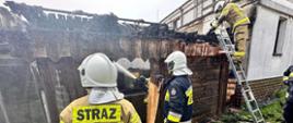 Na zdjęciu widać pracujących strażaków oraz spaloną altankę