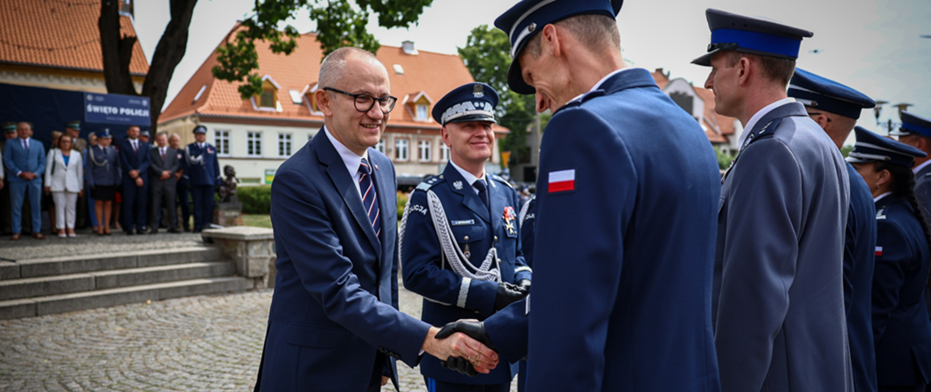 Wiceminister Błażej Poboży wraz z komendantem Jarosławem Szymczykiem składa gratulacje odznaczonym funkcjonariuszom