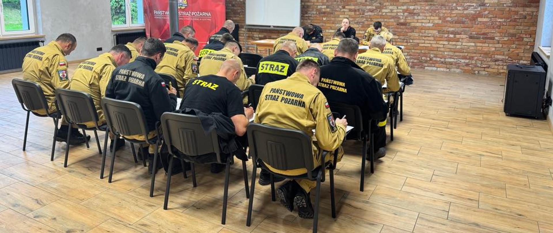 Strażacy piszą część teoretyczną egzaminu.