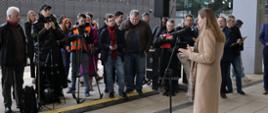 Na zdjęciu minister Katarzyna Pełczyńska-Nałęcz stoi na peronie, w tle widać dziennikarzy