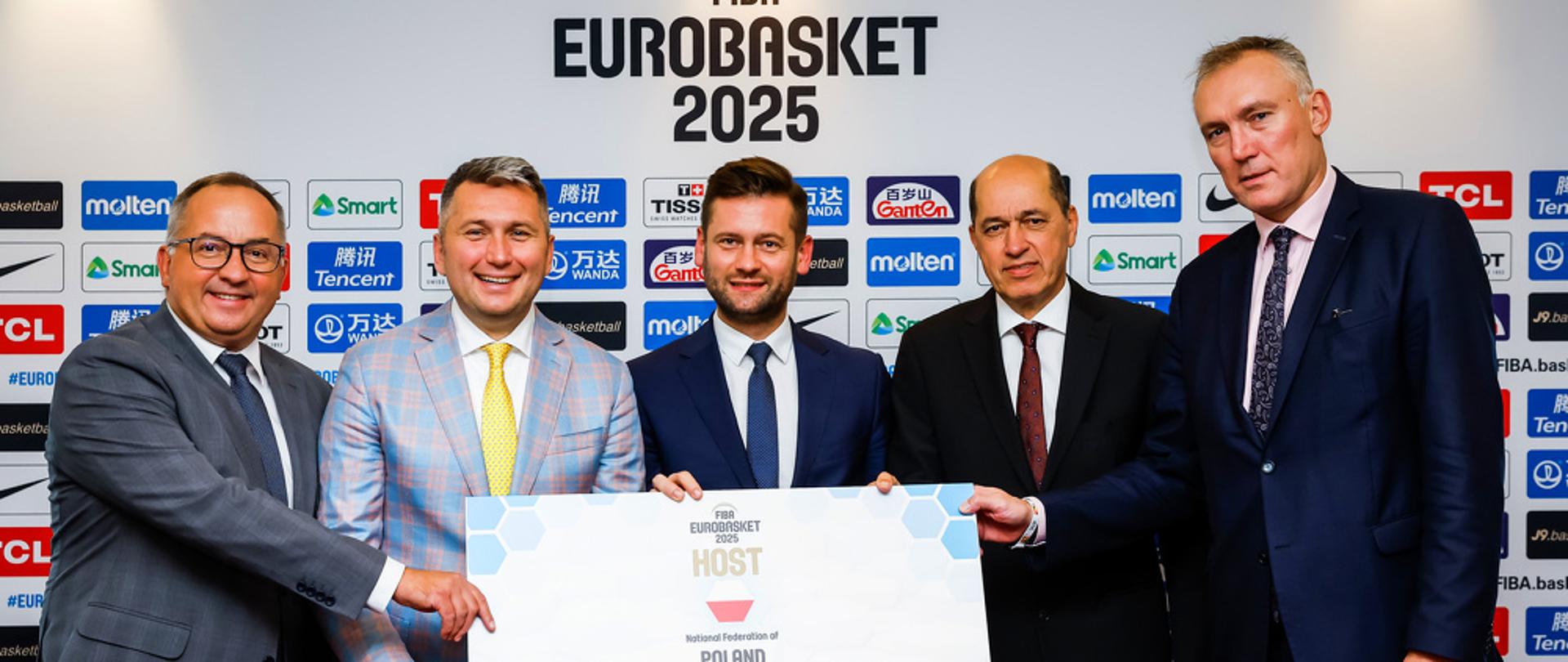 Polska współgospodarzem EuroBasketu 2025 - wspólne zdjęcie ministra sportu i turystyki, prezesa Polskiego Związku Koszykówki i przedstawicieli FIBA Europe.
