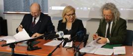 Zdjęcie z uroczystości podpisania umowy o dofinansowanie dla TPN. Od lewej siedzą: zastępca prezesa NFOŚiGW Robert Gajda, ministra klimatu i środowiska Paulina Hennig-Kloska i Dyrektor Tatrzańskiego Parku Narodowego Szymon Ziobrowski