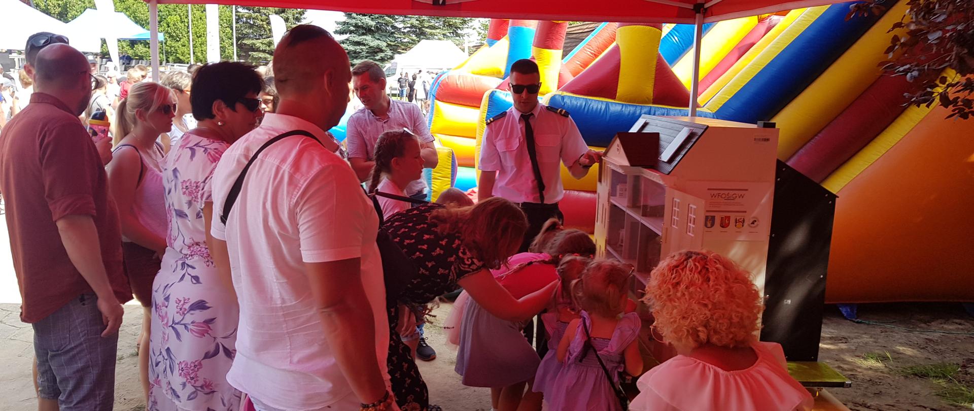 Zdjęcie przedstawia ludzi odwiedzających stoisko straży pożarnej podczas dożynek powiatowych.