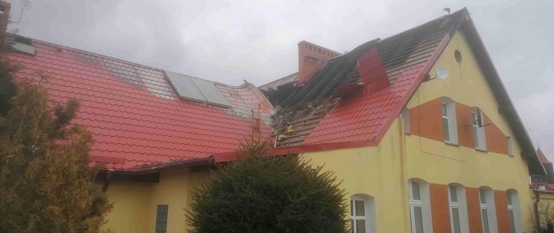 Budynek Szkoły Podstawowej w Biskupnicy, z dachu usunięta część poszycia i uwidoczniony obszar objęty pożarem - spalona drewniana konstrukcja dachu.