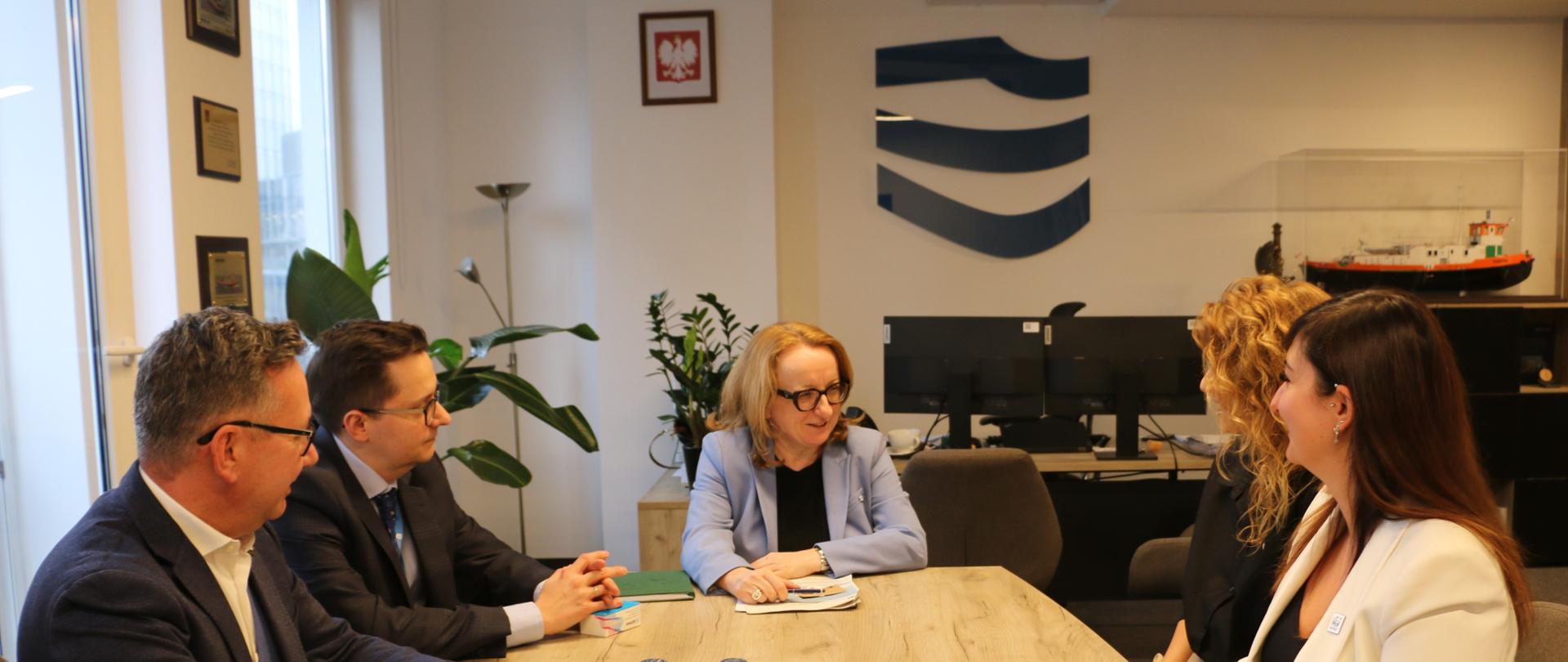 Spotkanie Prezes Wód Polskich z przedstawicielami WWF - goście rozmawiają przy stole w gabinecie