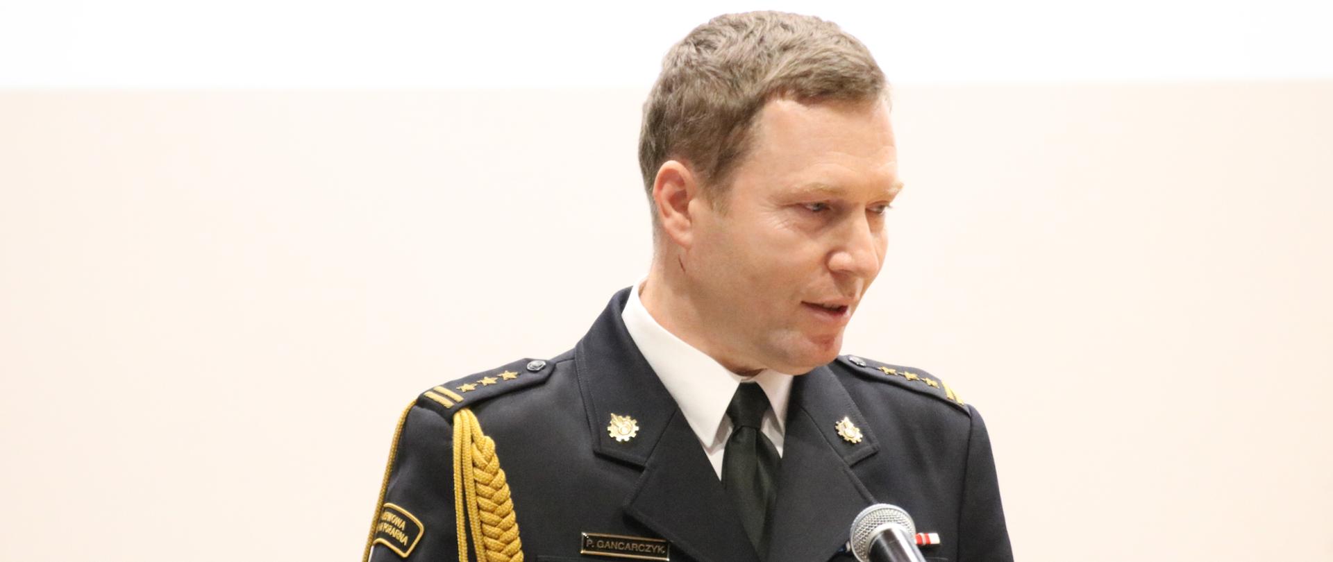 St.bryg. Piotr Gancarczyk przemawia ze sceny szkolnej auli