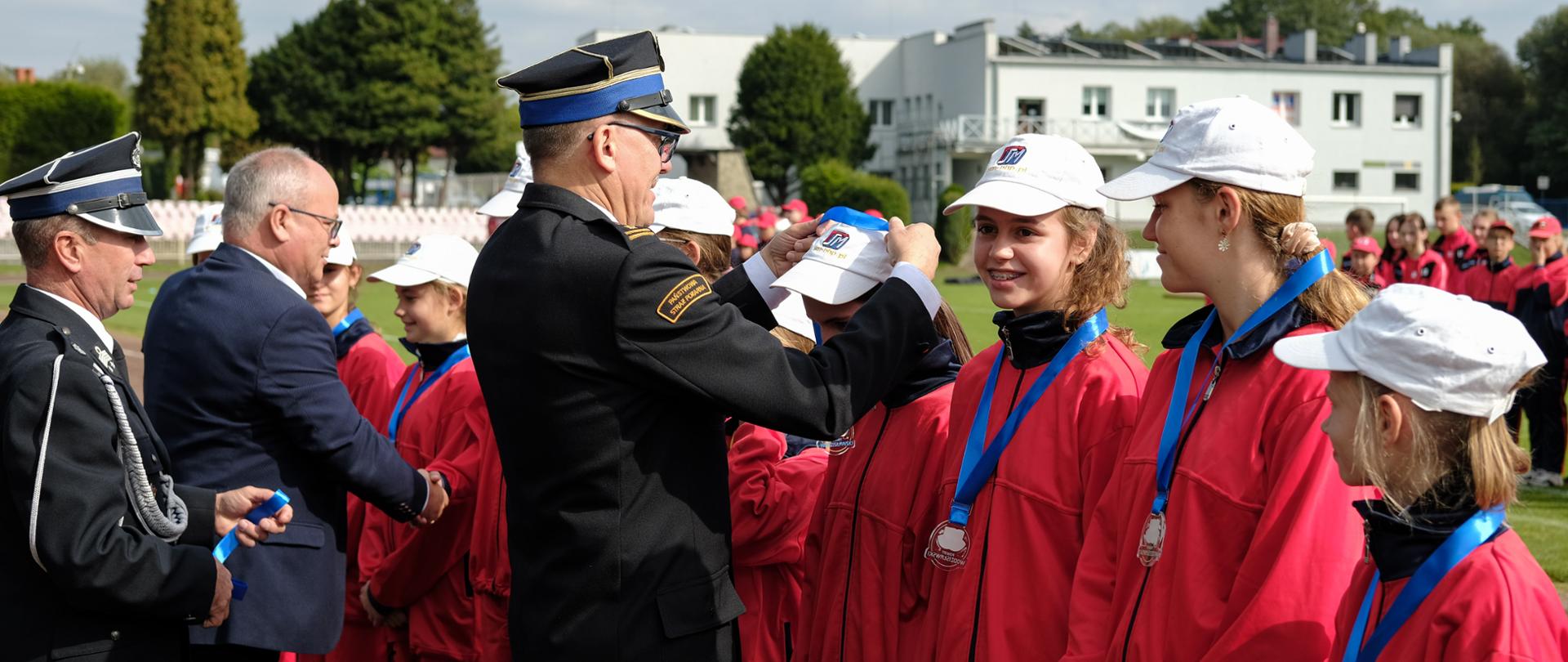 Na zdjęciu komendant dekoruje medalami zwycięską drużynę