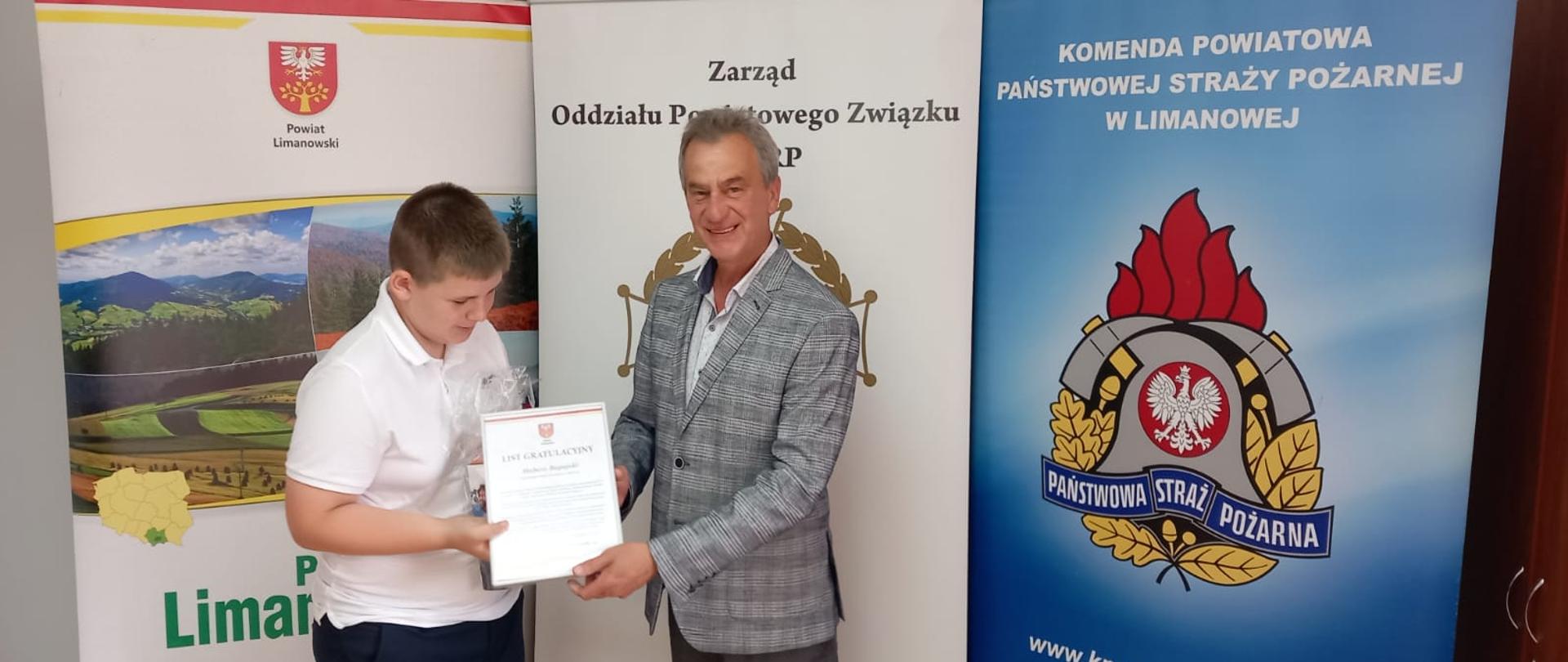 Starosta limanowski wręcza list gratulacyjny finaliście 45. Ogólnopolskiego Turnieju Wiedzy Pożarniczej.
