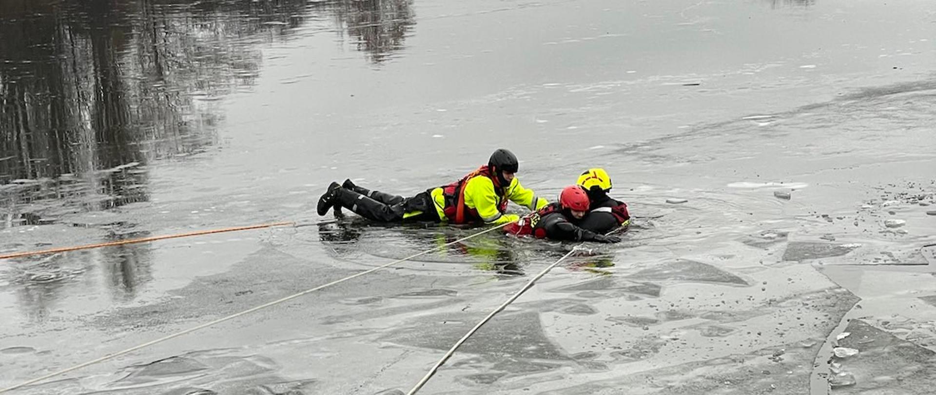Podejmowanie osoby poszkodowanej przez dwóch ratowników
