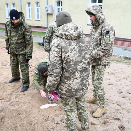 Grupa polskich i ukraińskich funkcjonariuszy w mundurach uczy się zabezpieczania śladów