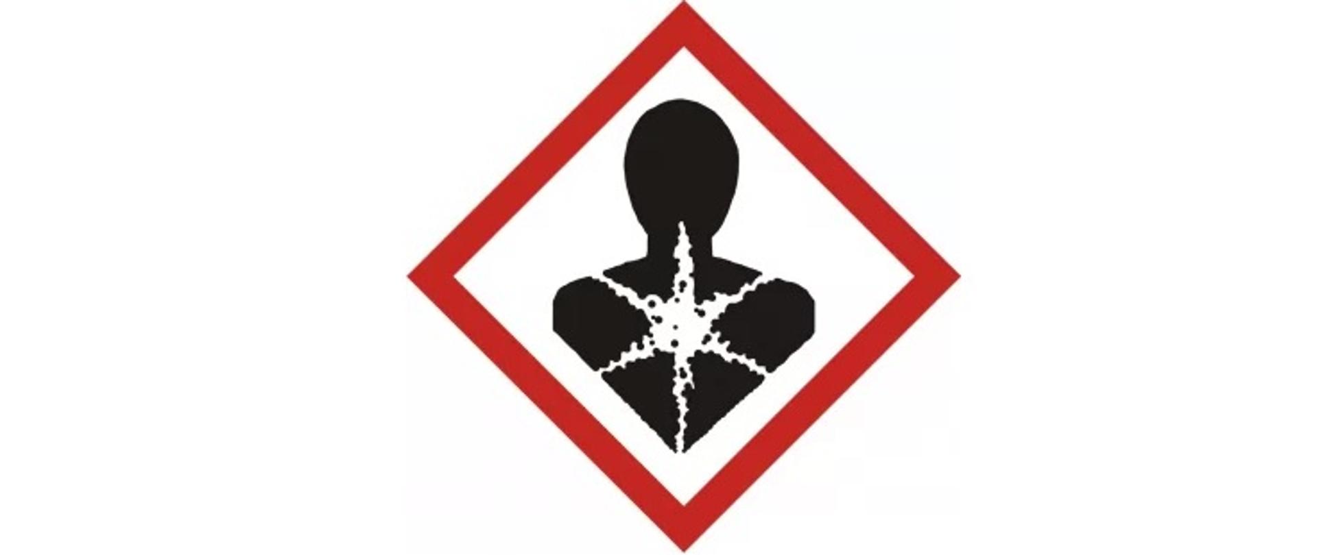 Czarna postać człowieka z umieszczonym na wysokości klatki piersiowej biały symbolem przypominającym gwiazdę. Całość umieszczona w czerwonej ramce w kształcie kwadratu ustawionego na czubku. 