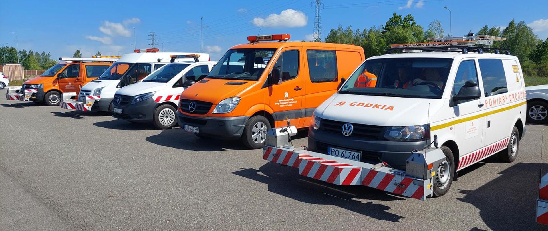 Samochody GDDKiA służące do prowadzenia badań laboratoryjnych, stoją na parkingu, trzy samochody mają zamontowane profilery