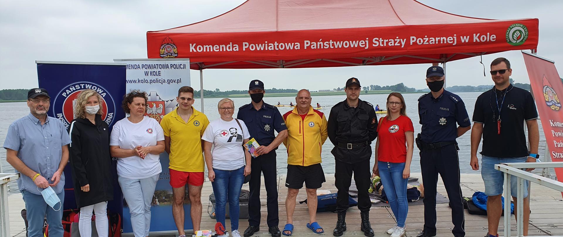 Zdjęcie przedstawia prowadzących zajęcia tj. ratowników medycznych, strażaka i policjanta podczas akcji prewencyjnej w ramach ogólnopolskiej kampanii :Kręci mnie bezpieczeństwo nad wodą"