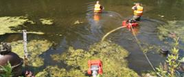 Na zdjęciu strażacy obsługują pompy pływające podczas ćwiczeń w rzece