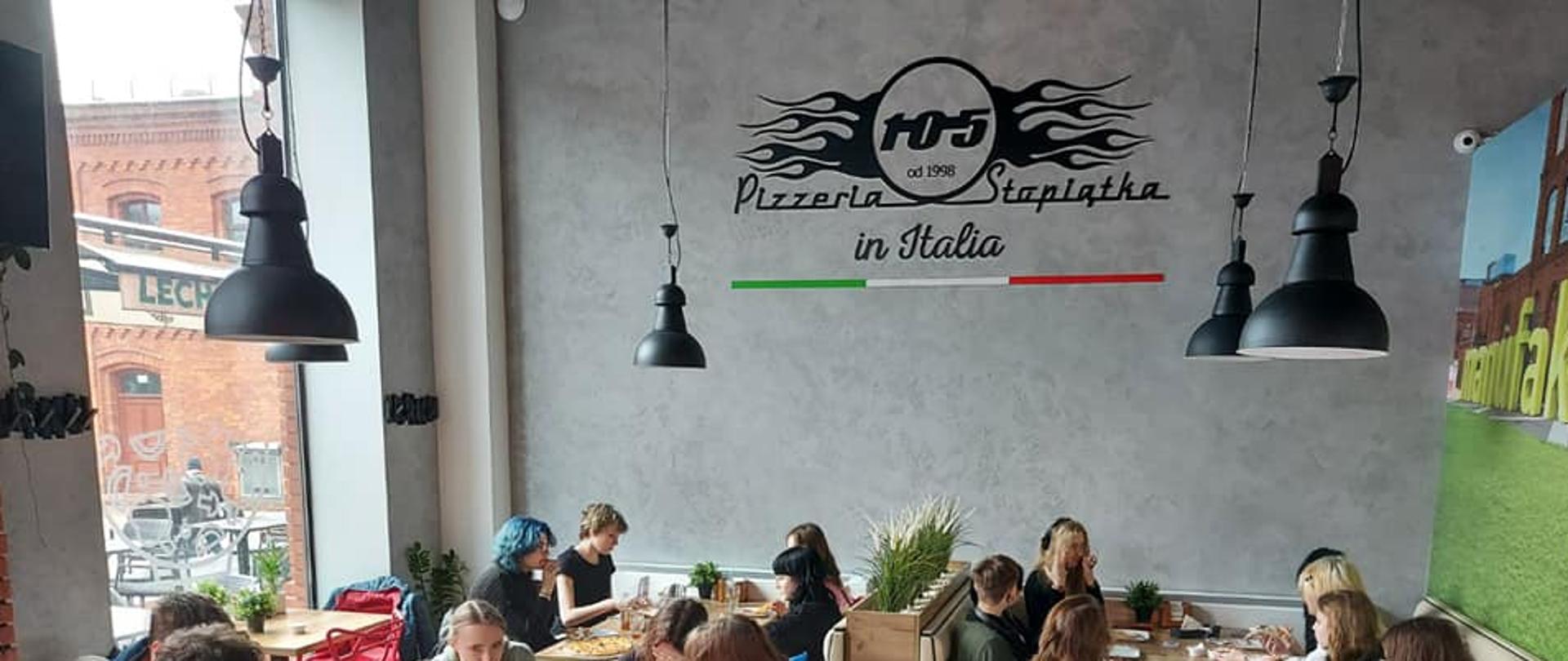 Na zdjęciu wnętrze lokalu. Młodzież siedzi przy stolikach