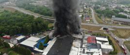 Zdjęcie wykonane z drona. Przedstawia budynki firmy objęte pożarem. 