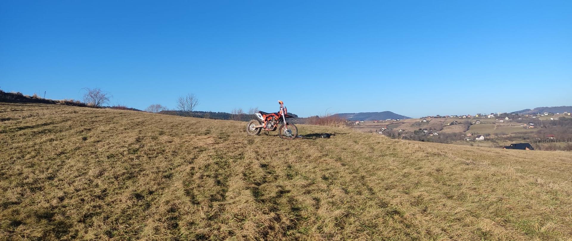 Motocykl stoi na łące.