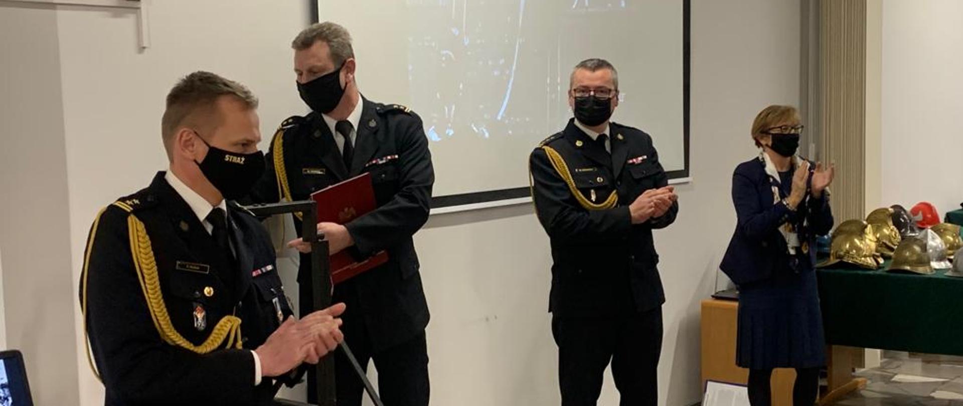 Na zdjęciu funkcjonariusze Państwowej Straży Pożarnej w umundurowaniu galowym w tracie przemówień podczas otwarcia wystawy "Bogu na chwałę, ludziom na ratunek"