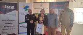 Pani Renata Wojtaś nagrodzona za przygotowanie dwóch uczniów (zwycięzców etapu wojewódzkiego) w poprzedniej edycji. Na zdjęciu z Komendantem PSP w Pińczowie, Wicestarostą Powiatu Pińczowskiego oraz Sekretarzem Zarządu Powiatowego Związku OSP RP w Pińczowie.