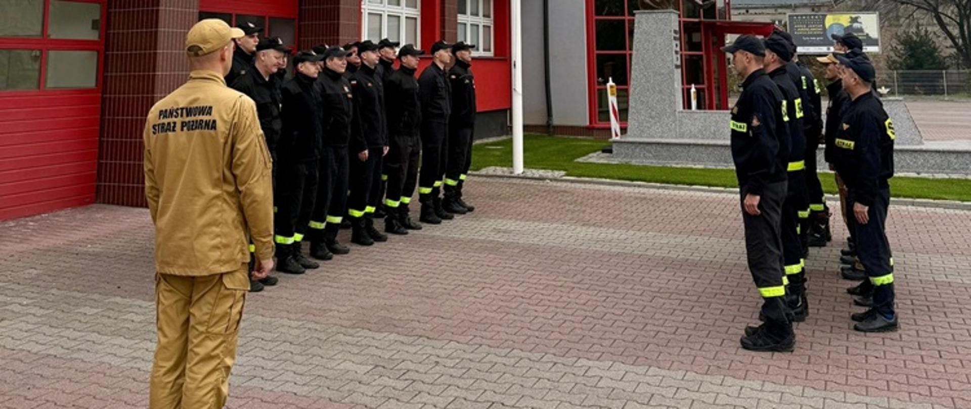 Strażacy stoją w szeregu podczas zmiany służby.