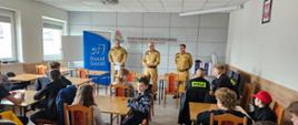 Przywitanie uczestników podczas eliminacji powiatowych Ogólnopolskiego Turnieju Wiedzy Pożarniczej "Młodzież Zapobiega Pożarom". Na salce zgromadzona młodzież w trzech kategoriach wiekowych. Uczestników kierownictwo Komendy Powiatowej PSP w Środzie Wielkopolskiej