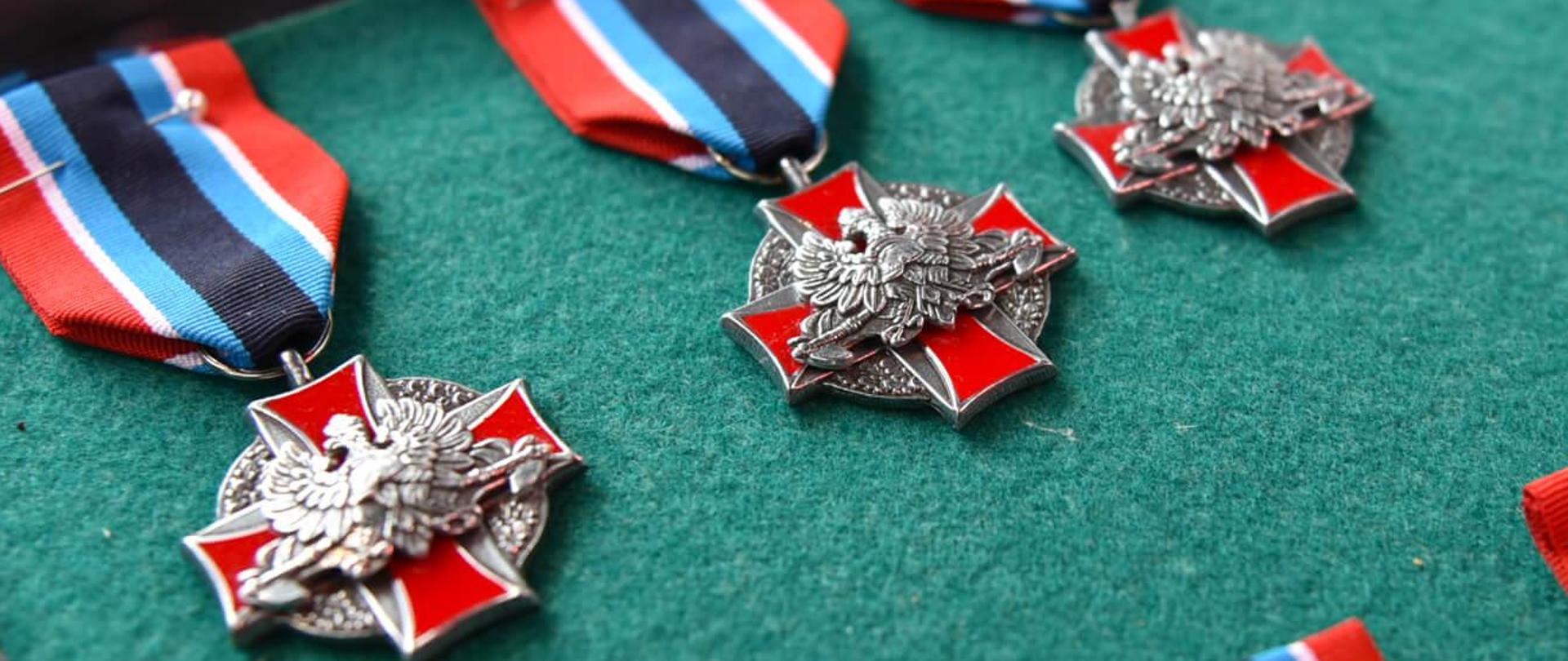 medale zasłużony dla pożarnictwa leżą na tacy na zielonym tle