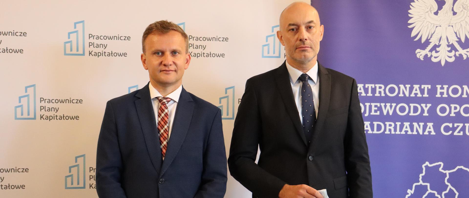 Na zdjęciu od lewej wiceprezes PFR oraz wojewoda opolski, pozujący do wspólnego zdjęcia. W tle ścianka promocyjna z napisem: "Pracownicze Plany Kapitałowe" oraz "Wojewoda Opolski". 