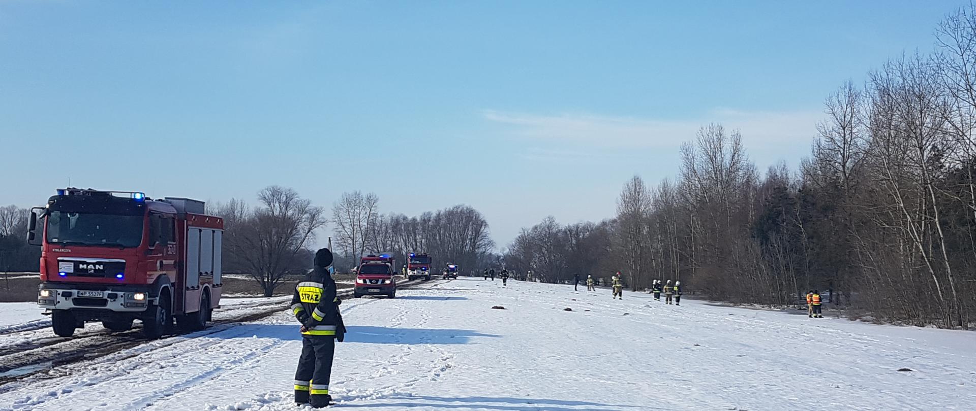 Samochody straży pożarnej, strażacy patrolują teren