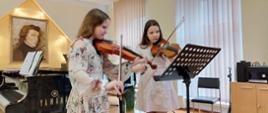 Dwójka uczennic grające na skrzypcach podczas audycji muzycznych 19 maja 2023 w auli PSM w Kłodzku