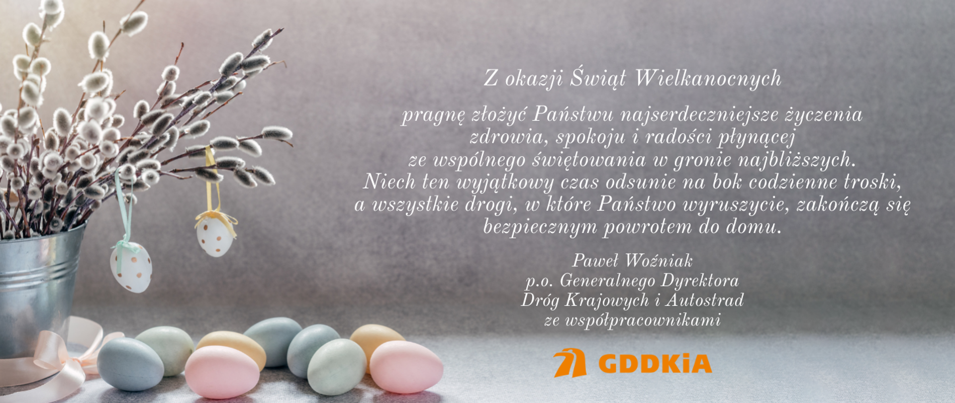 Na zdjęciu znajduje się życzenia wielkanocne od Pawła Woźniaka, pełniącego obowiązki Generalnego Dyrektora Dróg Krajowych i Autostrad, oraz jego współpracowników. Oprócz życzeń wielkanocnych, widoczny jest elegancki, wiosenny motyw graficzny. Tło jest jasne, z delikatnymi pastelowymi kolorami, które nadają całości świeżości i lekkości. W tle można dostrzec subtelne elementy dekoracyjne, takie jak kwiaty, gałązki oraz pisanki, które są charakterystyczne dla okresu wielkanocnego.